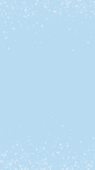 Fototapeta premium Snowfall overlay christmas background. Subtle flying snow flakes and stars on light blue winter backdrop. Festive snowfall overlay. Vertical vector illustration.