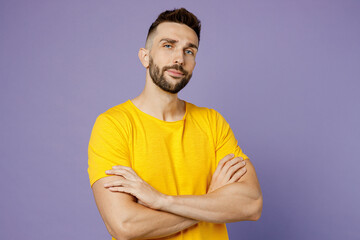 Young calm serious confident european caucasian man wearing yellow t-shirt looking camera hold...
