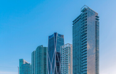 Fototapeta na wymiar Miami, Florida cityscape against the clear sky in the background. Row of modern glass buildings with different architectural exterior.
