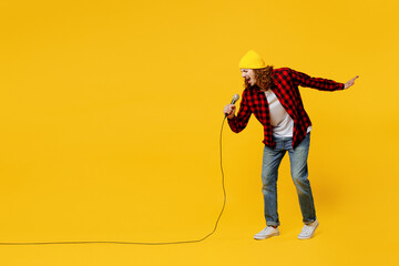 Full body side view fun singer young man wearing red checkered shirt white t-shirt hat sing song in...