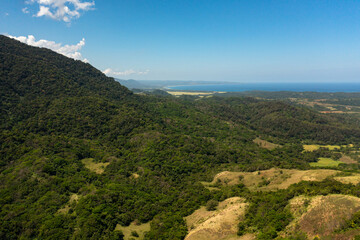 Top view of Mountains with forest and blue sea. Mountain slopes covered with rainforest. Philippines.