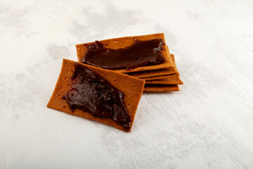 Rye crisps with thick Australian spread made from leftover brewers yeast extract, selective focus. Aussie savory chips with vegemite. Vegemite is a very popular yeast based spread in Australia.