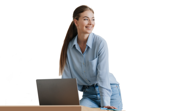 Gorgeous blonde young woman in blue shirt and blue jeans standing at desk with laptop looks aside toothy smiles against transparent background. Pretty female model with ponytail remote working home.