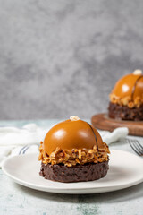 Round caramel cake. Hazelnut and cream portion cake