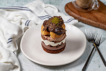 Layered profiteroles cake. Whipped cream, chocolate, and pistachio cake.