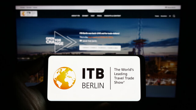Stuttgart, Germany - 03-19-2023: Person holding mobile phone with logo of German tourism trade fair ITB Berlin on screen in front of web page. Focus on phone display.
