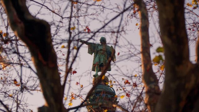 Christopher Columbus, view through the branches of trees.