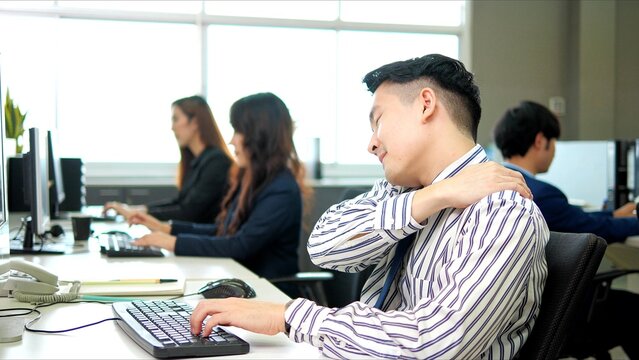 A office worker has experiences severe back pain because he sits at work for a long time and he is at risk of office syndrome