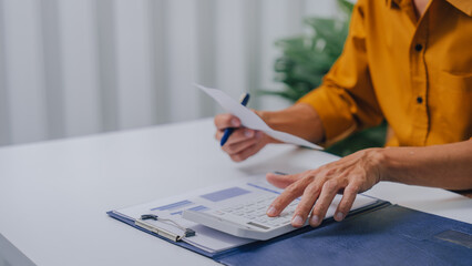 Fototapeta premium Young Serious asia people bookkeeper doing bookkeeping entrepreneur small business owner accountant in office with balance sheet, income tax return and budget of local business.