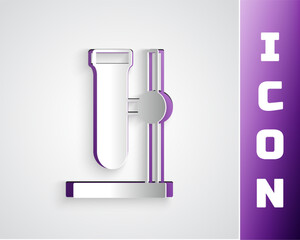 Paper cut Glass test tube flask on stand icon isolated on grey background. Laboratory equipment. Paper art style. Vector