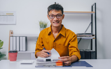 Young Serious asia people bookkeeper doing bookkeeping entrepreneur small business owner accountant in office with balance sheet, income tax return and budget of local business.