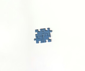 Pieces of a jigsaw puzzle that have been put together on a white background depicting teamwork and...