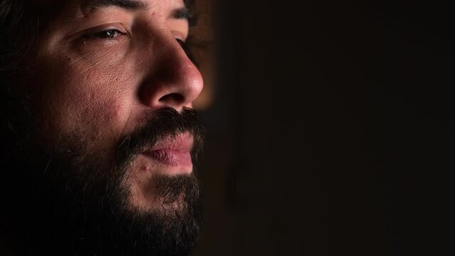 Close-up shot of Bearded man putting on teeth protector ferula splint, dark background