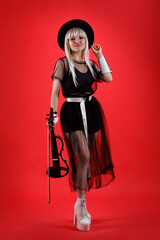 Violinist woman in the stage costume on the red background.