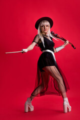Violinist woman in the stage costume on the red background.