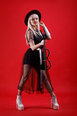 Violinist woman in the stage costume on the red background.