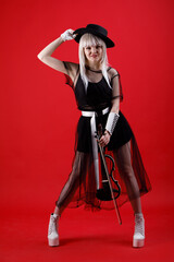 Violinist woman in the stage costume on the red background.