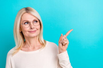 Photo of shiny dreamy lady dressed white shirt eyewear looking showing finger empty space isolated teal color background