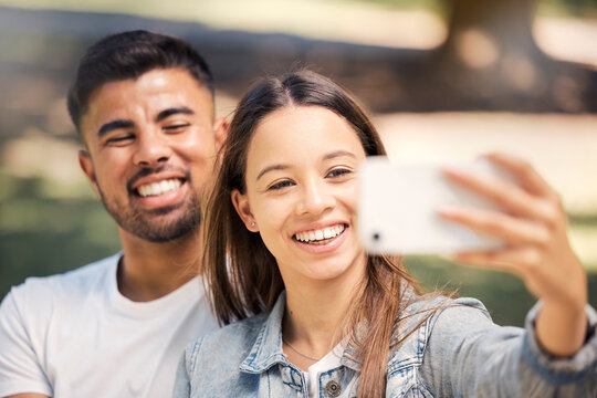 Outdoor, couple and smile with a selfie for love, care and happiness together in summer. Young man and woman at nature park for a profile picture on a happy and romantic date or vacation to relax