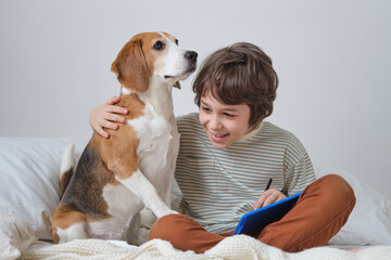 Adorable moment captured of a young boy embracing his beloved beagle, eyes closed in pure joy. Heartwarming photo of a child showing affection for his loyal four-legged friend