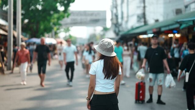 woman traveler visiting in Bangkok, Tourist with hat sightseeing in Chatuchak Weekend Market, landmark and popular attractions in Bangkok, Thailand. Travel in Southeast Asia concept