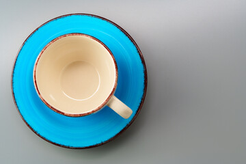 Top view of ceramic cup with saucer on gray background
