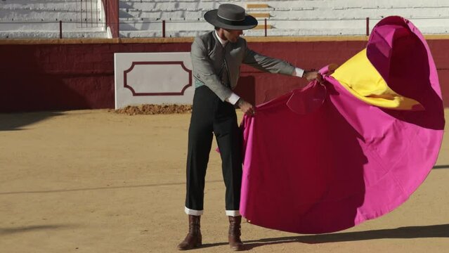 Bullfighter dressed in traditional matador costume from southern spain practicing with the cape in a bullring