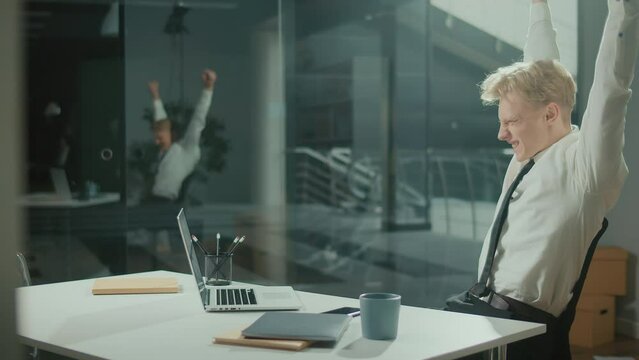 Engineer Bursting with Joy Reviewing Documents. Successful Man Making Profitable Deal and Celebrating the End of the Project.Young Smiling Architect Scatterring Papers around Him Waving Fists Happily