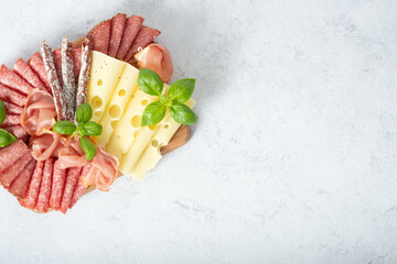 Delicacies. Cheese, prosciutto, salami on a wooden square board