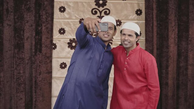 Two muslim men clicking selfie photos