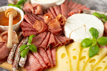 Delicacies. Cheese, salami on a wooden board