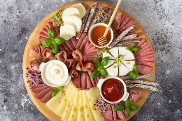 Delicacies. Cheese, salami on a wooden board