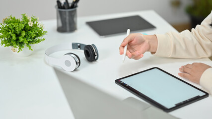 Creative freelancer hand holding stylus pen pointing on digital tablet, working online on new...