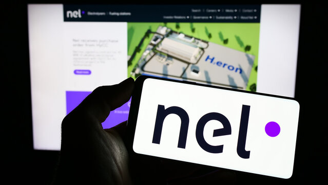 Stuttgart, Germany - 03-19-2023: Person holding smartphone with logo of Norwegian hydrogen company Nel ASA on screen in front of website. Focus on phone display.