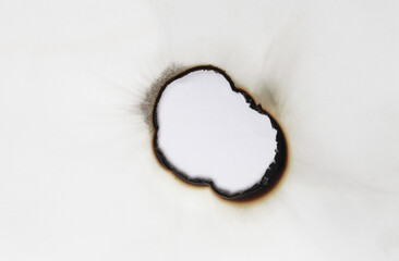 burned hole on a white paper background