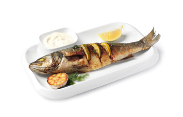 Plate with delicious roasted sea bass fish, garlic, slice of lemon and sauce on white background