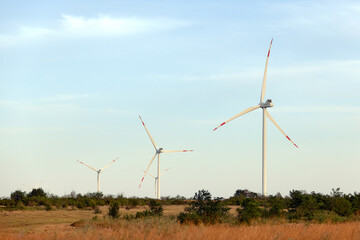 Silhouette of wind turbines at sunset. The concept of alternative energy.