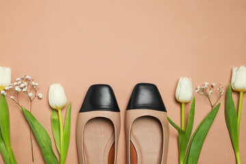 Flat lay composition with pair of new stylish square toe ballet flats and beautiful flowers on beige background. Space for text