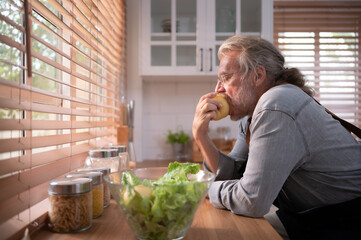 Grandpa in the kitchen with natural light, preparing for the day's dinner for the family.