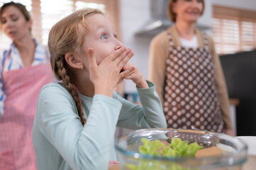 Granddaughter of grandparents in a kitchen with plenty of natural light Eat the salad grandma made for family dinner.