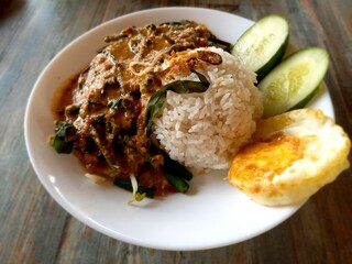 Pecel Madiun, Steamed Vegetables served with peanut sauce, cucumbar and fried eggs. close-up shot