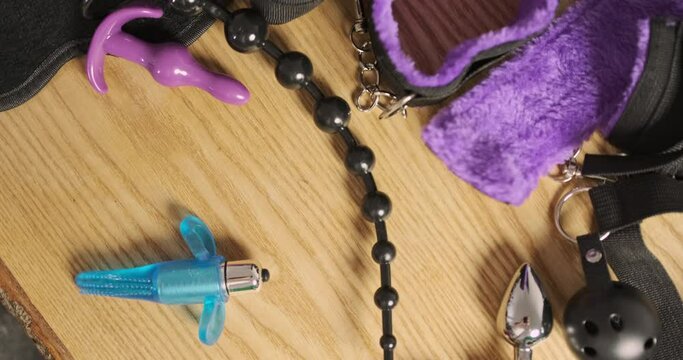 Small blue sex vibrator spins around the table. Top view, close-up. The concept of successful sex and sexual satisfaction.