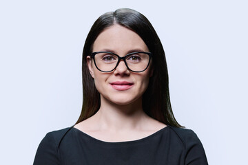 Young woman in black with glasses posing on white background