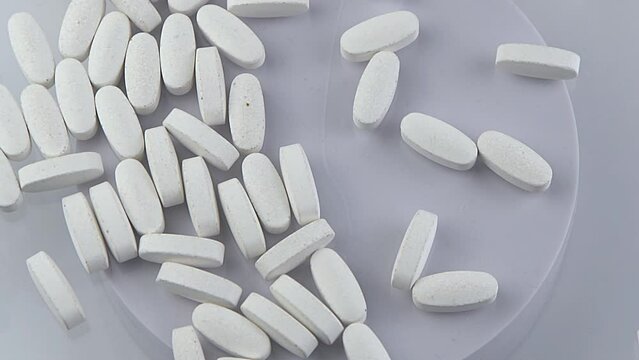 Lots of white pills. Vitamins and biological supplements. Medicine, treatment and pharmaceuticals. Tablet and pill capsule. Top view background