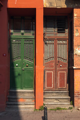 Green door and red door in the red wall.