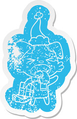 cartoon distressed sticker of a disgusted dog with christmas gift wearing santa hat