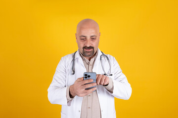 Holding using smartphone, middle aged male doctor holding using smartphone. Tele medicine concept...