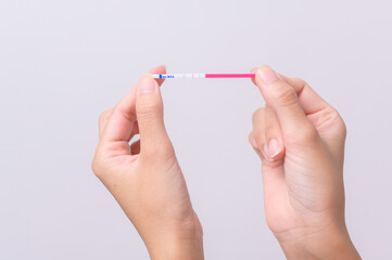 Close up woman using Ovalation (LH) test  or (HCG Pregnancy test) on white background
