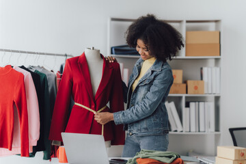 Happy smiling Asian creative fashion designer is working owner working in her tailor shop. Woman...