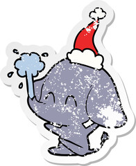 cute distressed sticker cartoon of a elephant spouting water wearing santa hat